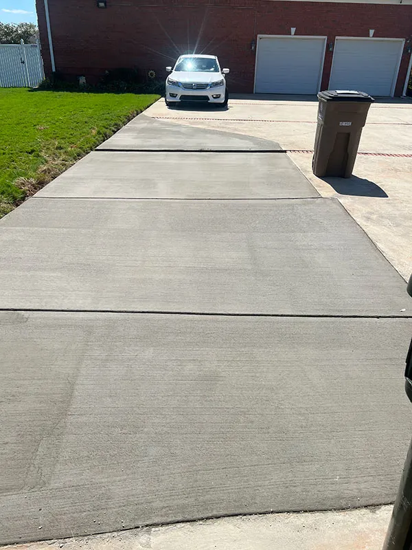 Concrete driveway leading to a two-car garage at an Alabama home