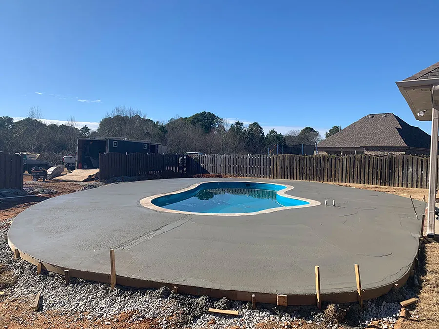 Freshly poured concrete pool deck under construction at an Alabama home